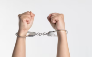 2 hands in handcuffs against a white background